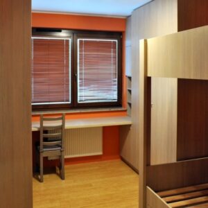 Мебель для детской с двухъярусной кроватью, распашными шкафами и компьютерным столом у окна
