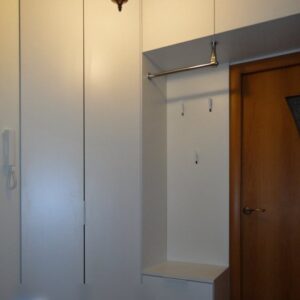 Мебель для прихожей в белом исполнении со шкафом, антресолью, тумбой и открытыми вешалками