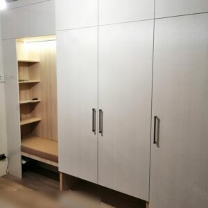 Мебель для прихожей с высокими распашными шкафами до потолка, мягким сиденьем и полками в нише с LED-подсветкой
