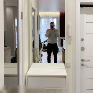 Небольшая белая подвесная консоль с одной выдвижной шуфлядкой и зеркалом в прихожую комнату возле входной двери