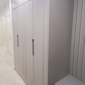 Прихожая серого цвета из крашеного МДФ с интегрированными ручками в узком коридоре
