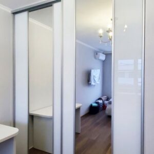 Двери-купе и гардеробные шкафы в спальне с фасадами из зеркала и стекла Лакобель