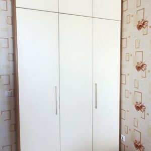 Трехдверный корпусный распашной шкаф до потолка на три двери для спальни с рейлинговыми ручками снизу и открытием от нажатия на антресолях