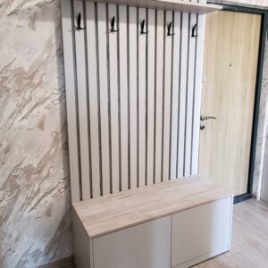 Реечная отделка стены в прихожей с крючками и напольной тумбой для обуви