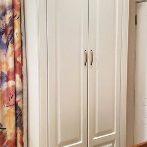 Белый шкаф для одежды с капителями и карнизом в классическом стиле в спальню напротив кровати